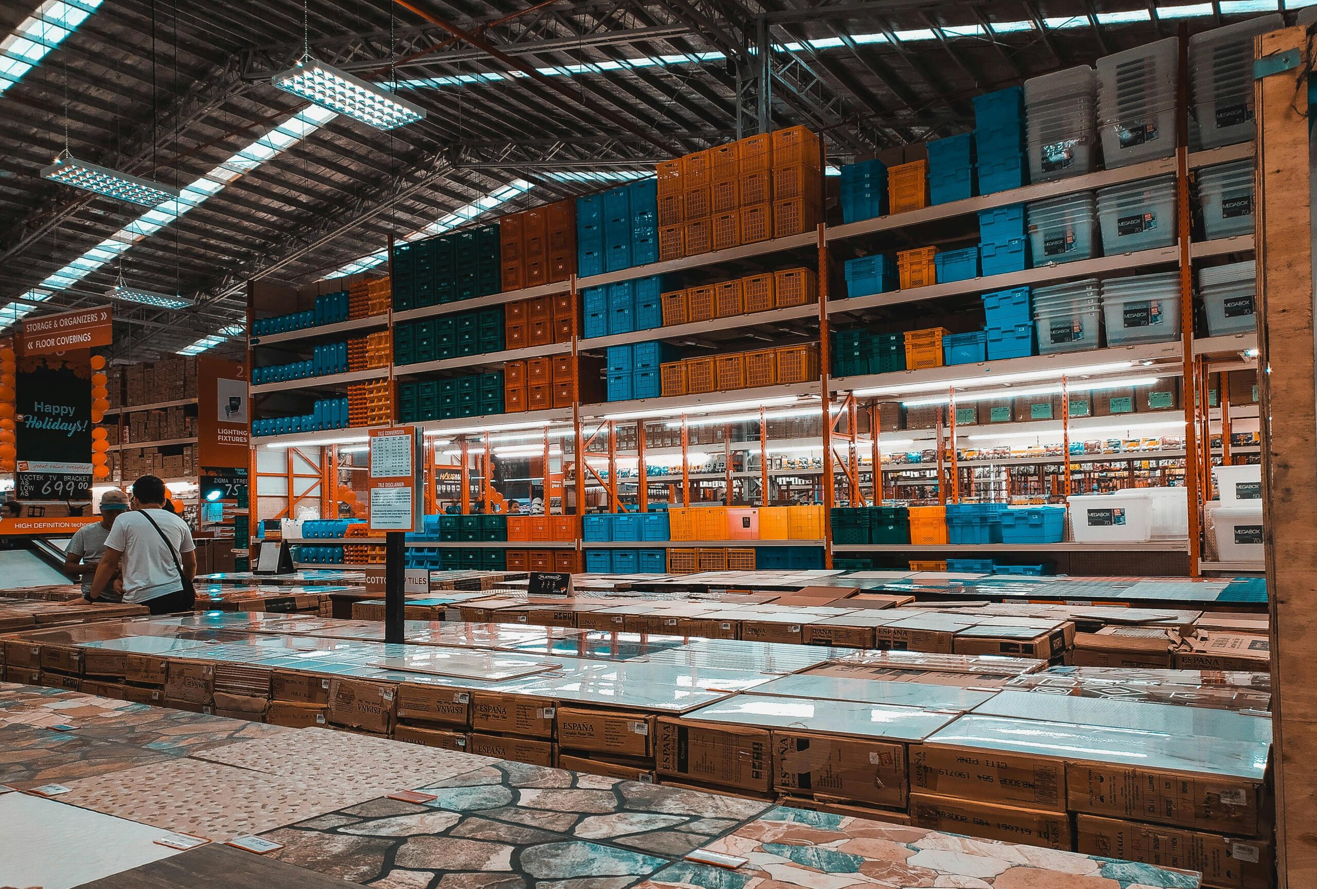 Spacious warehouse showcasing neatly arranged plastic containers on shelves under bright lighting.